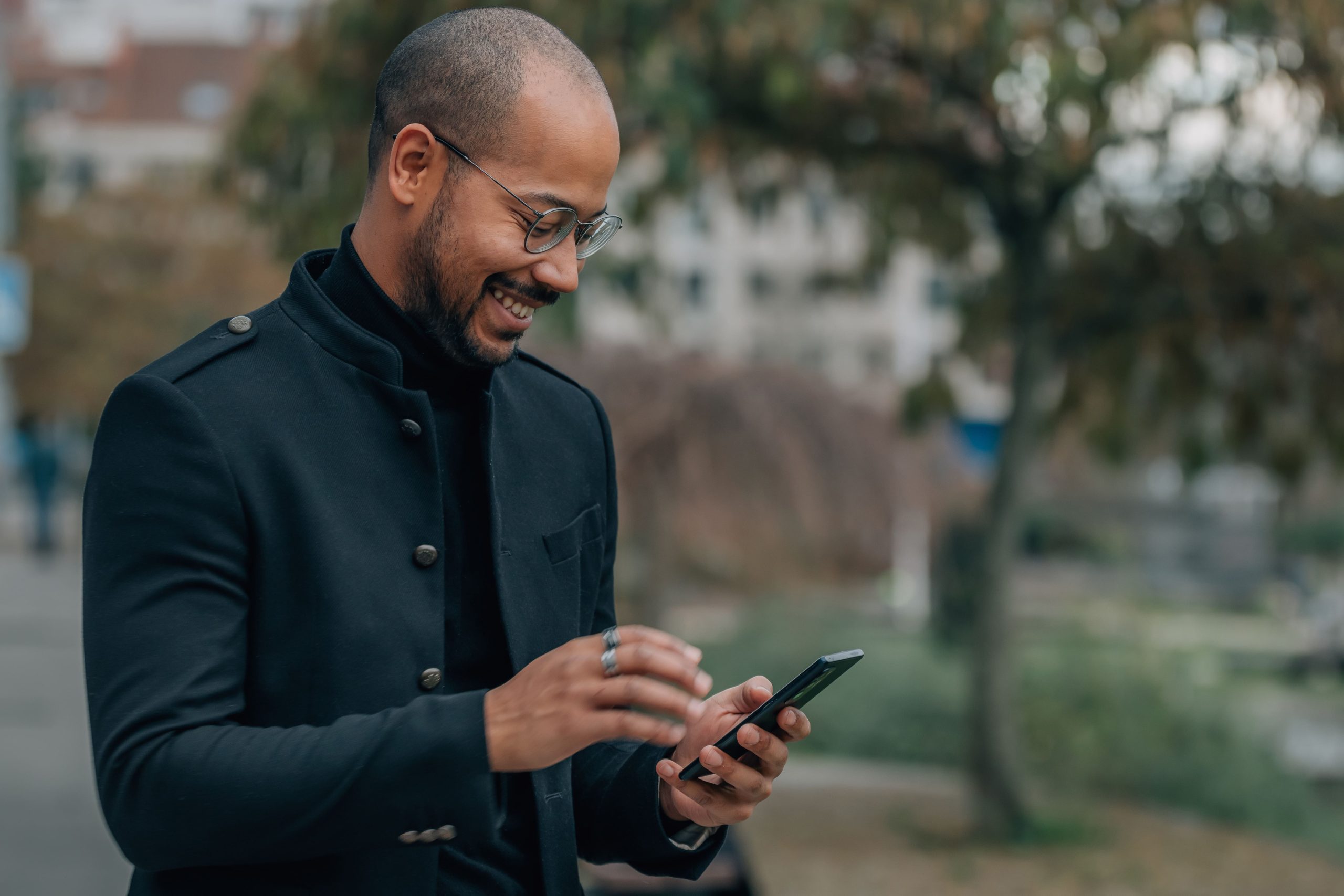 man in black jacket using phone
