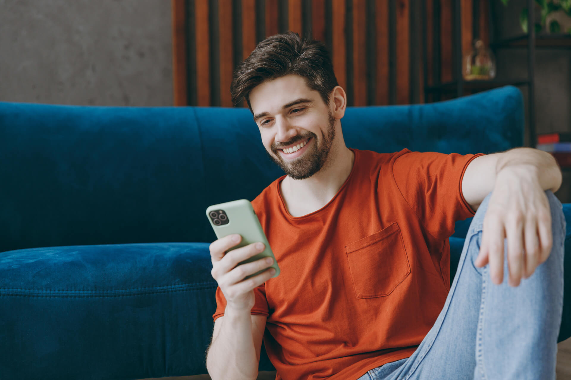 Young man wears red t-shirt hold in hand use mobile cell phone