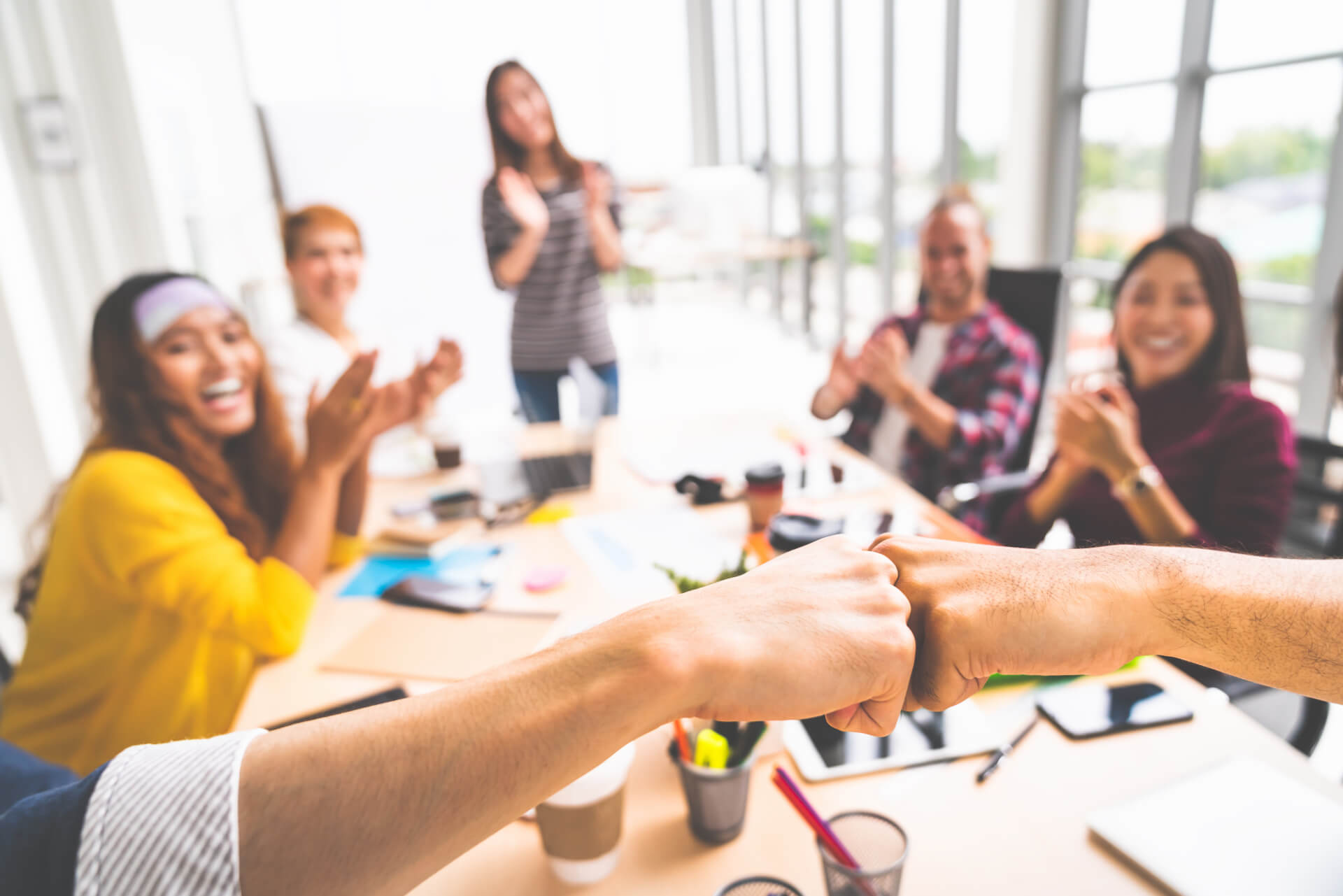 Business partners or men coworkers fist bump in team meeting