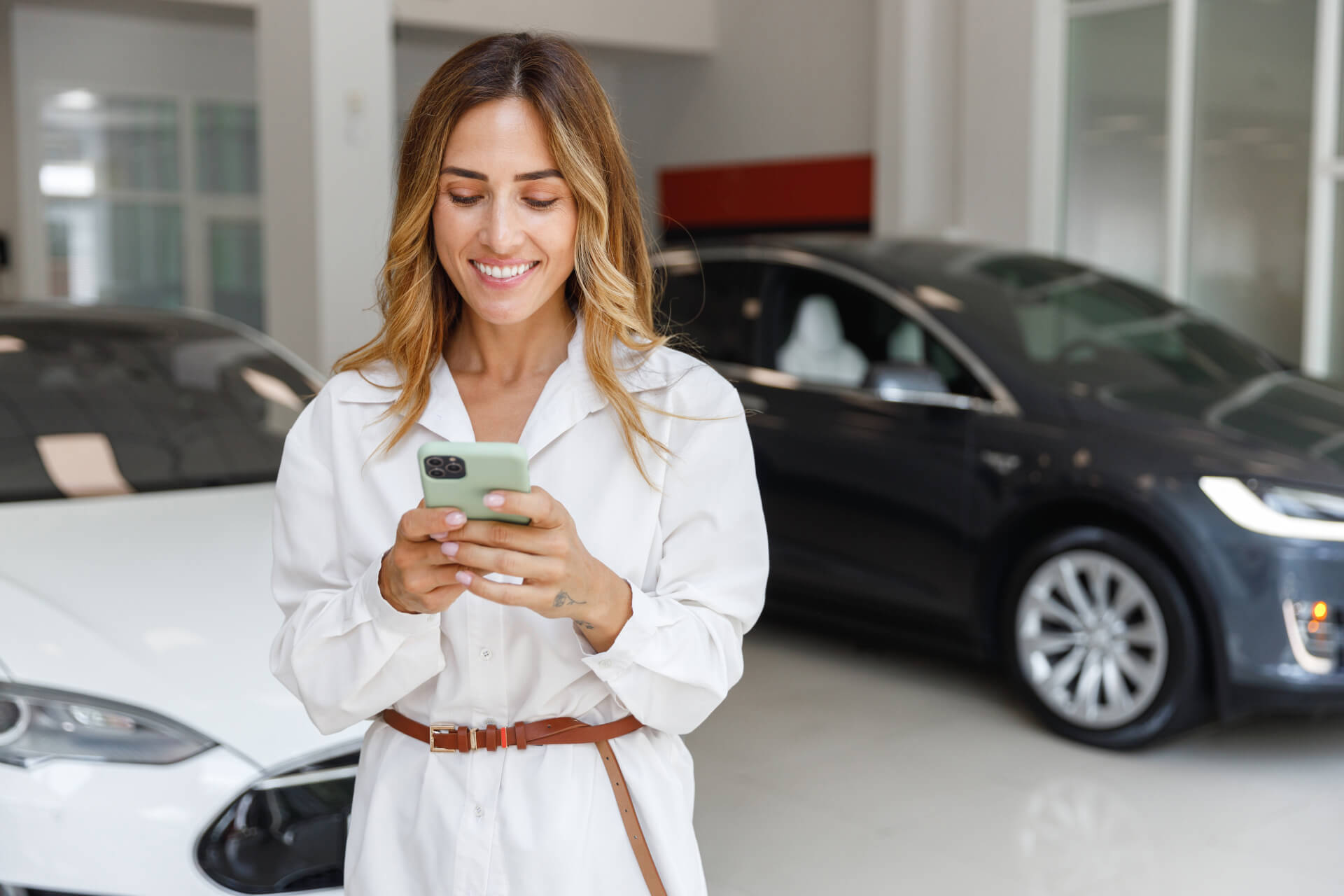 Happy woman customer female buyer client in white shirt using mobile cell phone